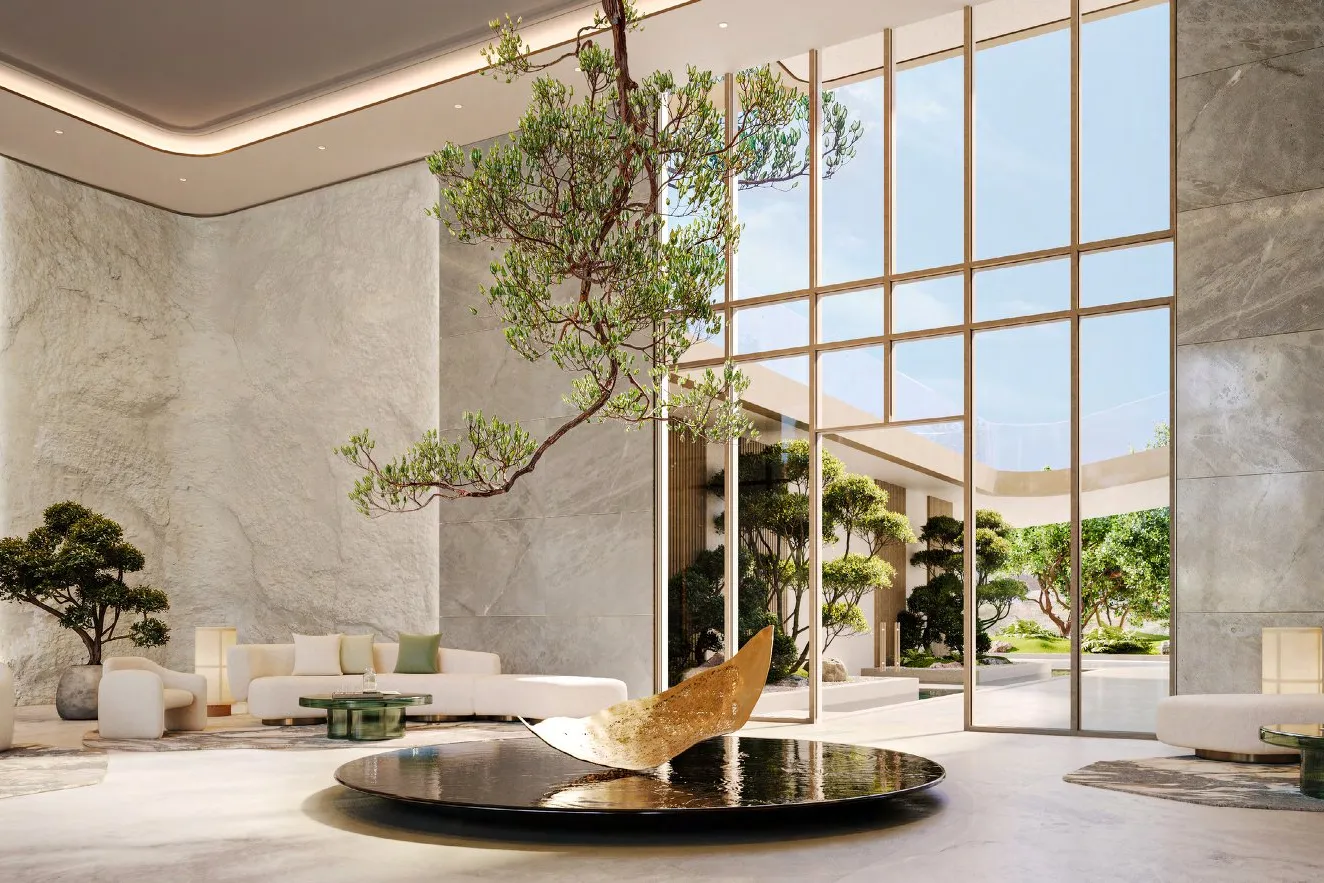 Lobby with stone walls, suspended tree and sculpture over a still pool